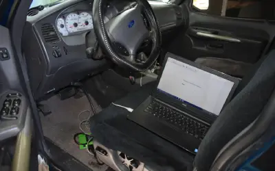 A laptop sitting in the back of a car.